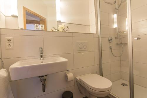 a bathroom with a sink and a toilet and a shower at Gasthof Hirsch Vorderburg in Rettenberg