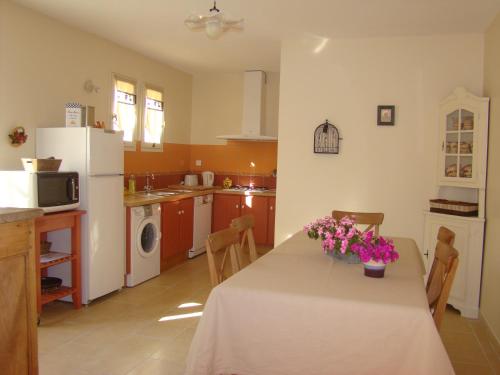 - une cuisine avec une table et des fleurs dans l'établissement La Maison de Lestang, à Montbeton
