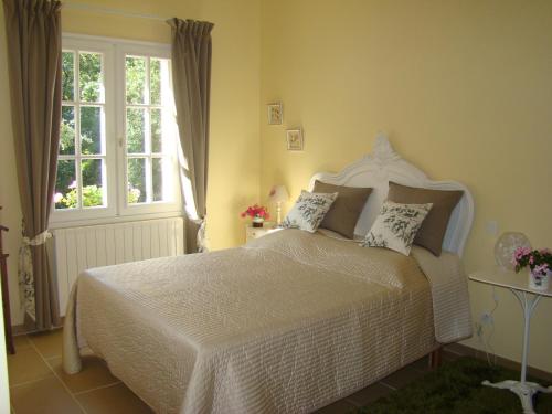 um quarto com uma grande cama branca com almofadas em La Maison de Lestang em Montbeton