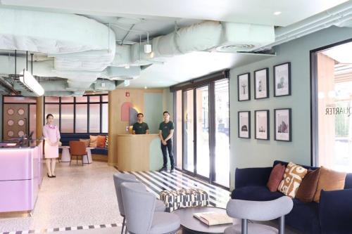a group of people standing in a waiting room at The Quarter Ratchathewi by UHG in Bangkok