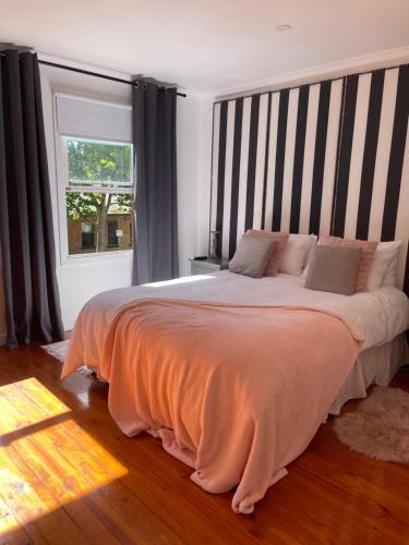 a bedroom with a large bed with a striped headboard at Luxury Fitzroy House in Melbourne