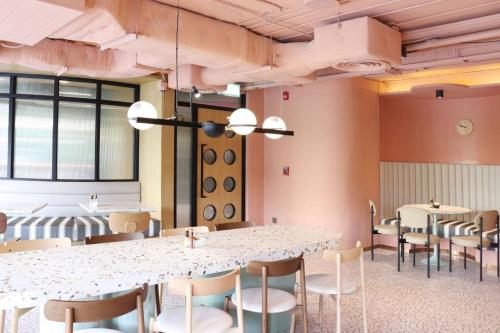 a dining room with white tables and chairs at The Quarter Ratchathewi by UHG in Bangkok