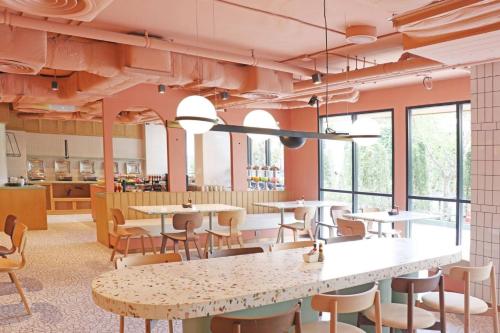 a restaurant with tables and chairs and windows at The Quarter Ratchathewi by UHG in Bangkok