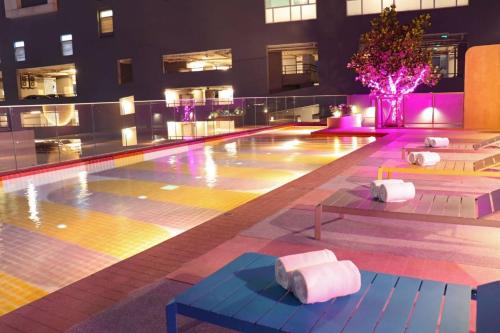 a pool in a building with lit up lights at The Quarter Ratchathewi by UHG in Bangkok