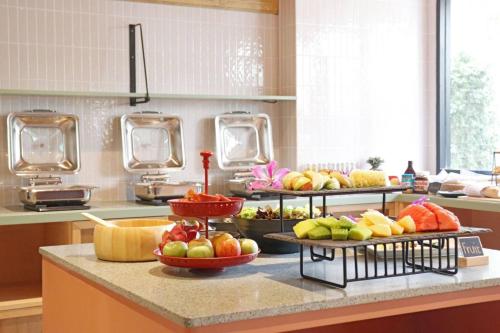 a kitchen with several plates of fruit on a counter at The Quarter Ratchathewi by UHG in Bangkok