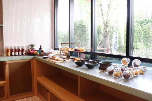 a kitchen with a counter with some food on it at The Quarter Ratchathewi by UHG in Bangkok