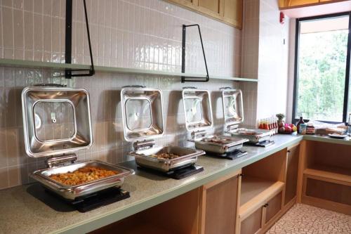 a kitchen with several trays of food on a counter at The Quarter Ratchathewi by UHG in Bangkok