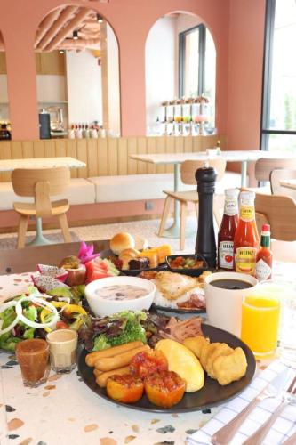 a table with a plate of food on a table at The Quarter Ratchathewi by UHG in Bangkok