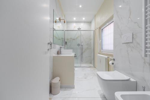 a white bathroom with a toilet and a shower at Leia Hospitality in Milan