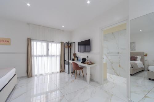 a white room with a desk and a bed at Leia Hospitality in Milan