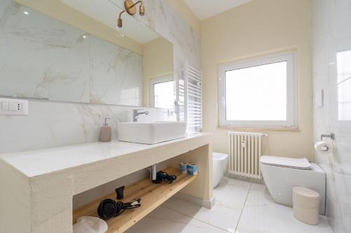 a white bathroom with a sink and a toilet at Leia Hospitality in Milan