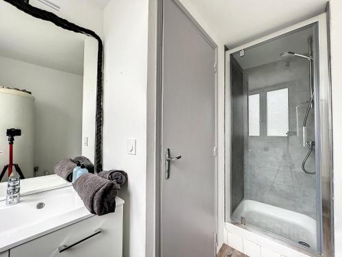 une salle de bain avec douche et porte vitrée dans l'établissement Breizh Appart, à Morlaix