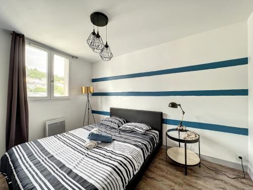 a bedroom with a bed with blue and white stripes at Breizh Appart in Morlaix