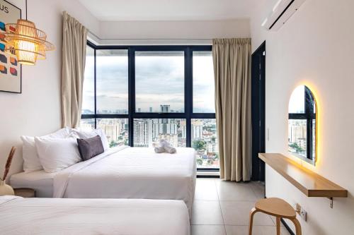 Urban Suites, Classic Collection by Stellar ALV في Jelutong: سريرين في غرفة الفندق مع نافذة كبيرة