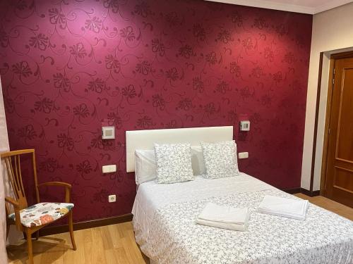 a bedroom with a bed with a red wall at Hostal New Dream Madrid in Madrid