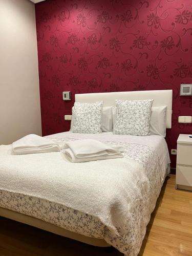 a bedroom with a white bed with a red wall at Hostal New Dream Madrid in Madrid