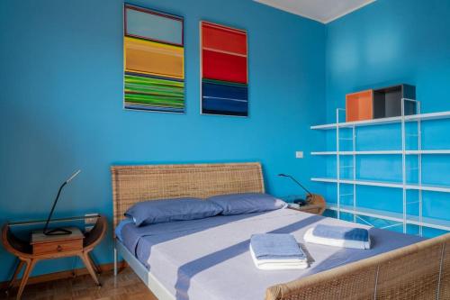 1 dormitorio azul con 1 cama y 1 silla en La Casa dell’Artista - Appartamento, en Milán