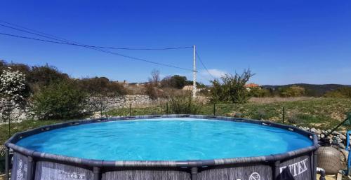 un bain à remous dans un champ avec un ciel bleu dans l'établissement Mas Demoiselle - Charmante maison 6 personnes, à Tornac