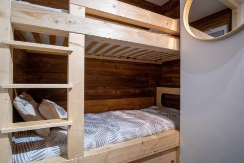 a wooden bunk bed in a room with a mirror at Studio Maona - skis au pied in LʼHuez