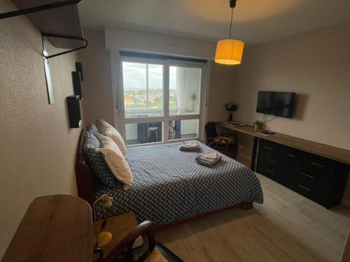 um pequeno quarto com uma cama e uma janela em Studio 24 - Coucher de Soleil & Vue Mer em Courseulles-sur-Mer