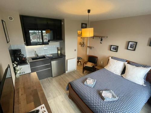 a small living room with a bed and a kitchen at Studio 24 - Coucher de Soleil & Vue Mer in Courseulles-sur-Mer