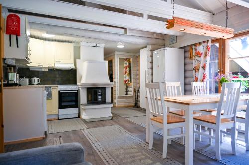 a kitchen and dining room with a table and chairs at Rukajärven Lomamajat Cottage 3 in Kuusamo