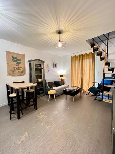 ein Wohnzimmer mit einem Sofa und einem Tisch in der Unterkunft Appartement Livingstone -2 pers. in Charleville-Mézières