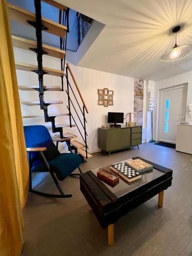sala de estar con escalera de caracol y silla azul en Appartement Livingstone -2 pers., en Charleville-Mézières