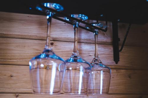 three wine glasses are hanging on a wall at Kuro Glamping in Stepantsminda