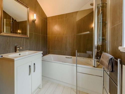 a bathroom with a tub and a sink and a mirror at 2 bed property in Llandysul 88775 in Llanfihangel-ar-Arth
