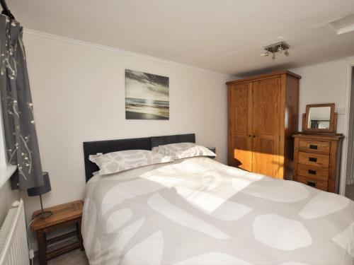 sypialnia z dużym łóżkiem i drewnianą szafką w obiekcie 2 Bed in Clovelly FORDM w mieście Woolfardisworthy