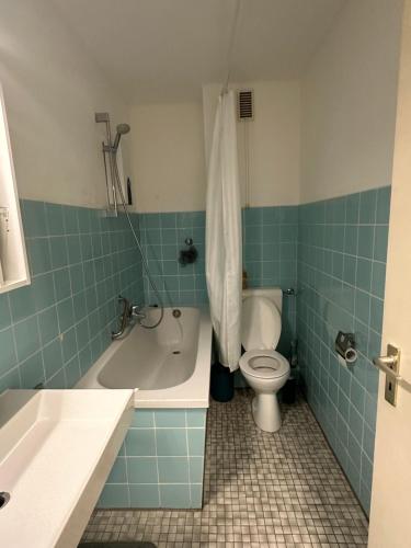 ein Badezimmer mit einer Badewanne, einem WC und einem Waschbecken in der Unterkunft Stay-Happy Flat in Halstenbek in Halstenbek