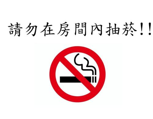 a sign with a no smoking sign with chinese characters at Chong Yu Hotel in Taoyuan