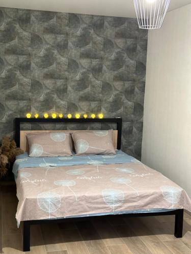 a bedroom with a bed with a stone wall at The Cube in Kremenchuk