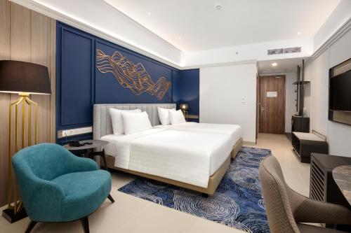 a bedroom with a bed and a blue wall at The Sentra Manado in Manado