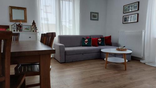 uma sala de estar com um sofá e uma mesa em Apartament z Napoleonem w tle em Lidzbark Warmiński