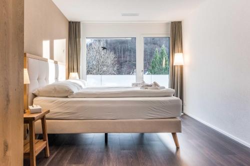 dwa łóżka w pokoju z oknem w obiekcie Apartment Alpeglöggli - GriwaRent AG w mieście Interlaken