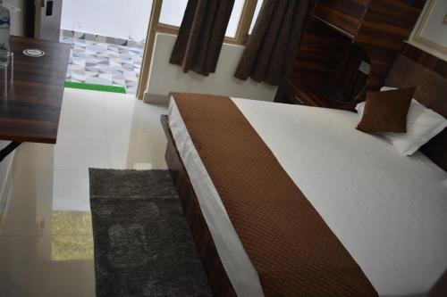 a bedroom with a bed and a wooden table and a tableablish at Chopta House Hotel and Restaurant in Sari