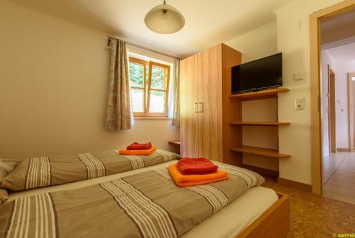 レオガングにあるFerienwohnung in Leogangのオレンジ色の枕が備わるホテルルームのベッド2台