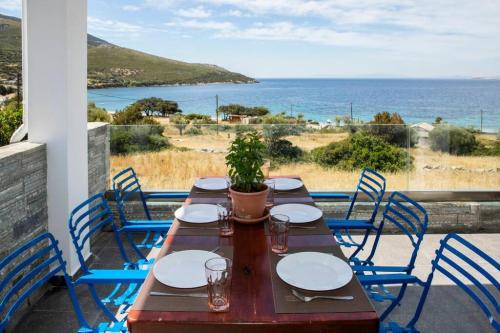 a wooden table and chairs with a view of the ocean at Seaview Villa in Nimporio in Nimporio