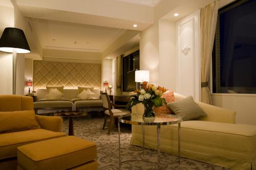a hotel room with a couch and a table with flowers at Hotel Okura Tokyo Bay in Urayasu