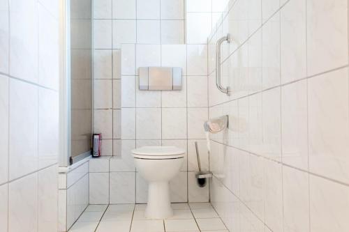 a white bathroom with a toilet and a shower at Work & Stay Apartment Goch in Goch