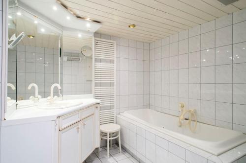 Baño blanco con bañera y lavamanos en Work & Stay Apartment Goch en Goch