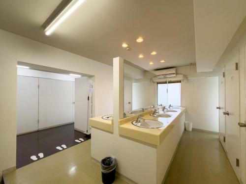 baño con 2 lavabos y espejo grande en Fukuoka Share Hotel, en Fukuoka