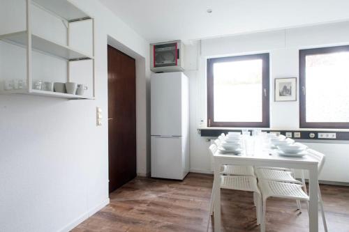 a white kitchen with a white table and chairs at Work & Stay Apartment Goch in Goch