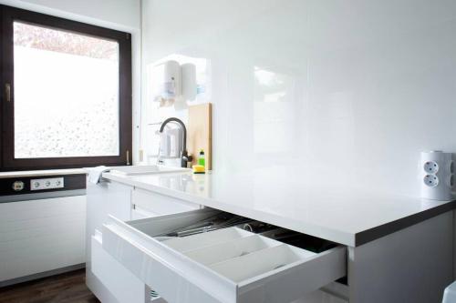 a white kitchen with a sink and a window at Work & Stay Apartment Goch in Goch
