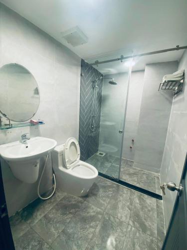 uma casa de banho com um chuveiro, um WC e um lavatório. em T~ONE HOSTEL em Cái Răng