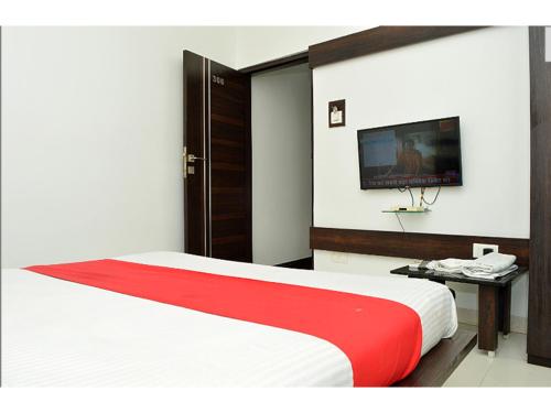 a bedroom with a bed and a tv on the wall at HOTEL SUNIL INN in Raipur