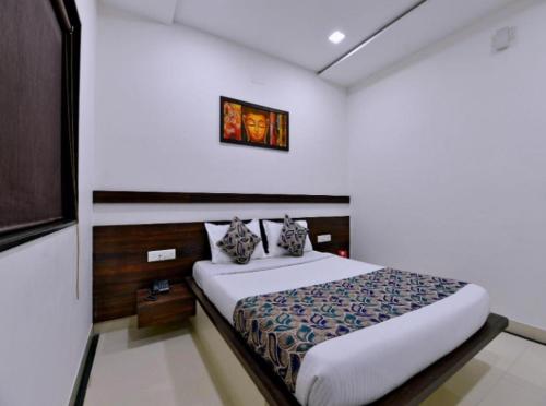 a bedroom with a bed and a picture on the wall at HOTEL SUNIL INN in Raipur