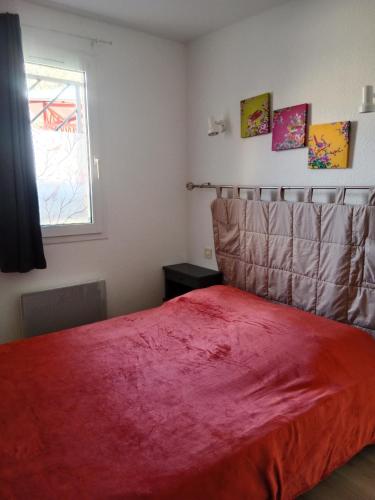 - une chambre avec un lit et une couverture rouge dans l'établissement Digne vallon des sources, à Digne-Les-Bains